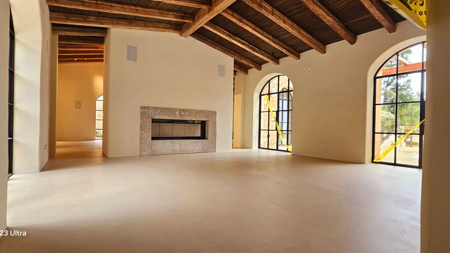 Salón con suelo continuo de micromortero y vigas de madera